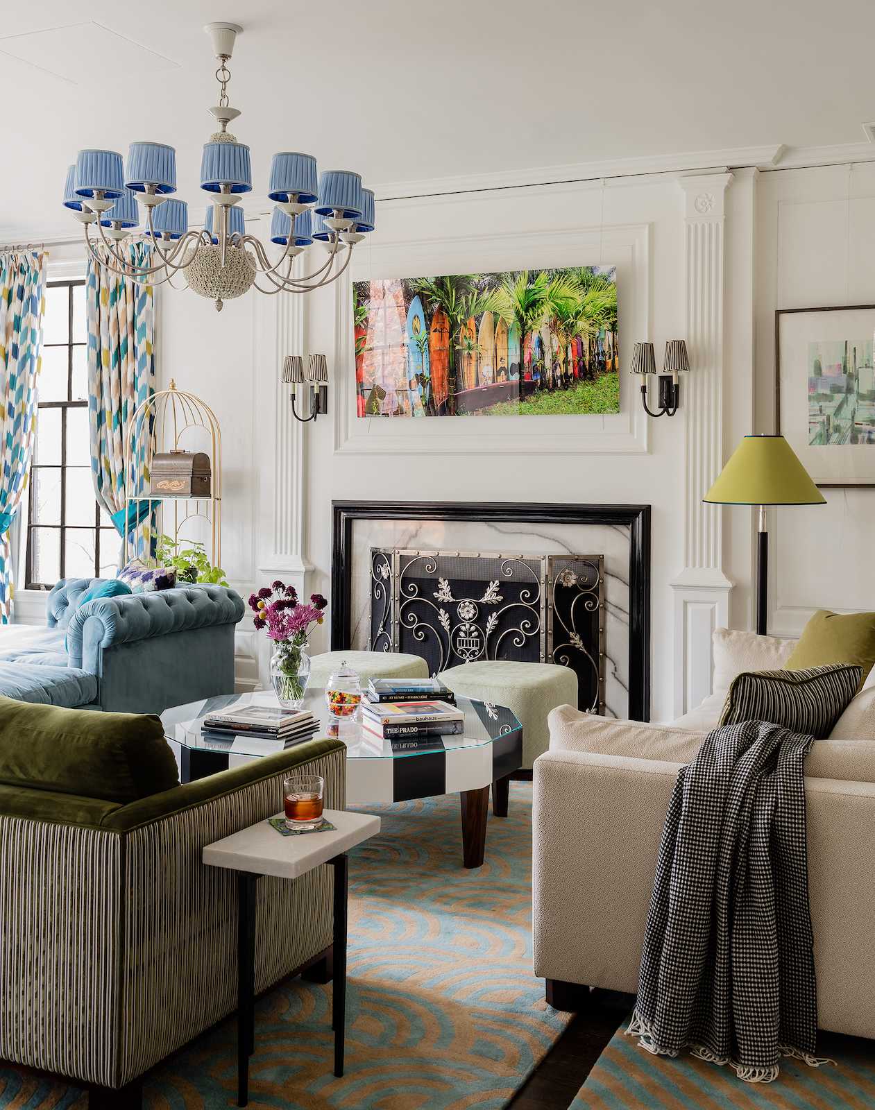 At a party everyone needs a place to set their drink. Here, a huge custom dodecagon coffee table with black and white stripes, side tables and ottomans with trays rise to the occasion.