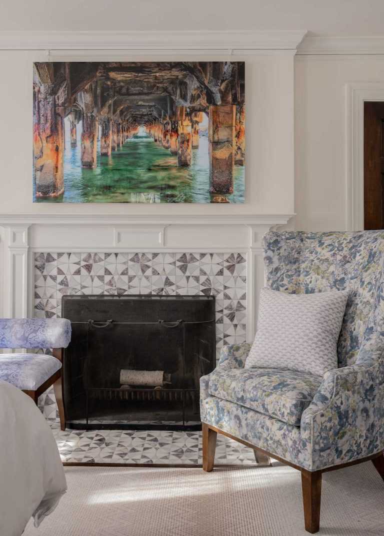 Chairs flanking the fireplace - with a lilac thassos marble mosaic surround - create a reading area.